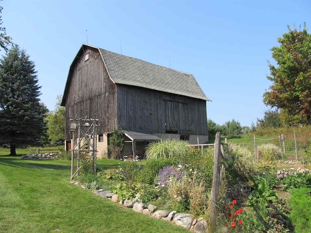 4251 Terpening Rd, Harbor Springs, MI 49740 - view of side of property featuring a gambrel roof, a lawn, an outbuilding, roof with shingles, and a barn