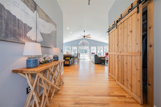 6001 N Silver Pines Dr, Bellaire, MI 49615 - corridor featuring a barn door, light wood-type flooring, lofted ceiling, and recessed lighting