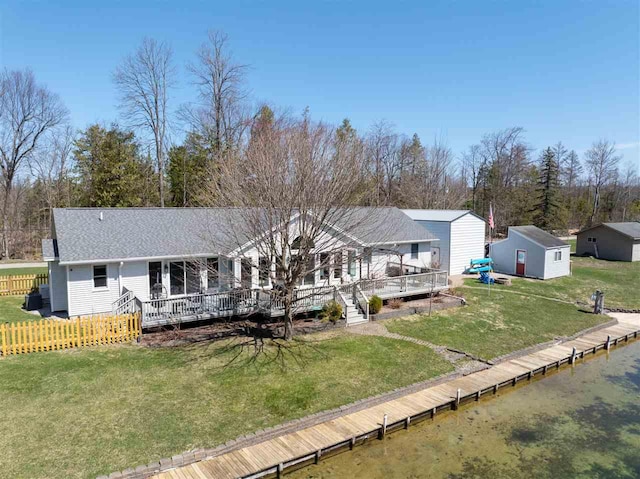 6001 N Silver Pines Dr, Bellaire, MI 49615 - rear view of house with a storage shed, a lawn, a deck, fence, and an outbuilding