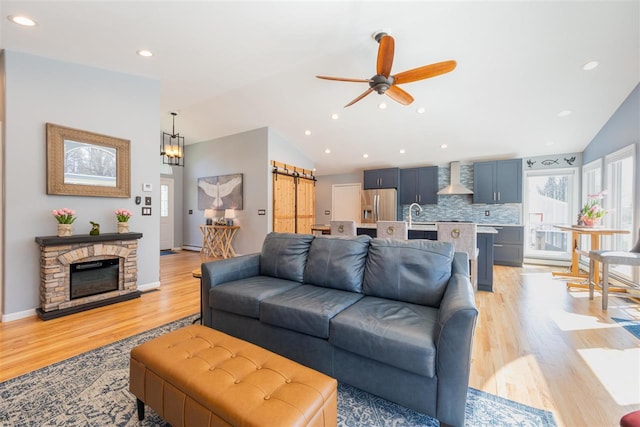 6001 N Silver Pines Dr, Bellaire, MI 49615 - living area featuring recessed lighting, vaulted ceiling, ceiling fan with notable chandelier, and light wood-style flooring