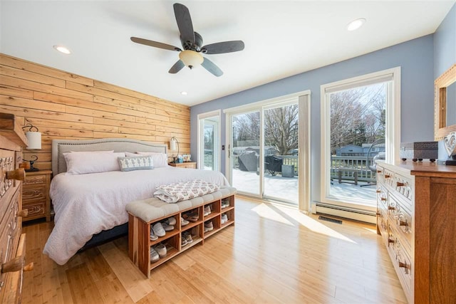 6001 N Silver Pines Dr, Bellaire, MI 49615 - bedroom featuring a baseboard heating unit, light wood-style flooring, recessed lighting, access to outside, and wooden walls
