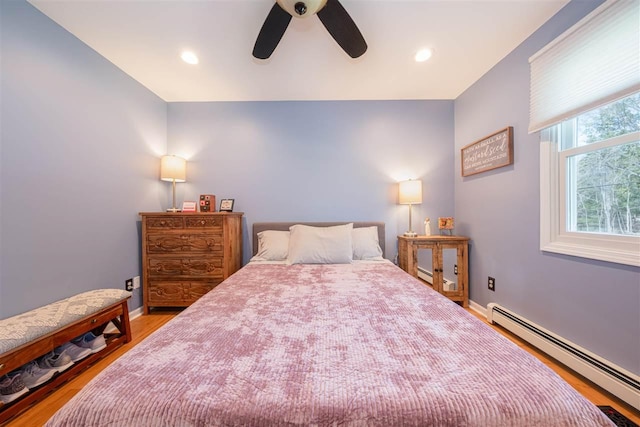 6001 N Silver Pines Dr, Bellaire, MI 49615 - bedroom featuring baseboards, wood finished floors, and a baseboard radiator