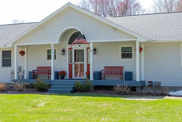 6001 N Silver Pines Dr, Bellaire, MI 49615 - view of front of property with roof with shingles, a porch, and a front lawn