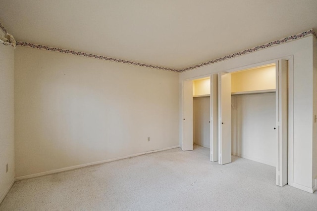 1871 Cherry Hill Ct, Harbor Springs, MI 49740 - unfurnished bedroom featuring two closets, baseboards, and light colored carpet