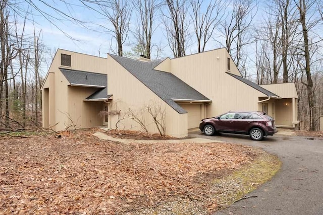 1871 Cherry Hill Ct, Harbor Springs, MI 49740 - view of property exterior with a shingled roof, driveway, and a chimney