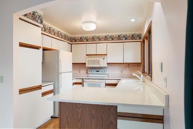 1871 Cherry Hill Ct, Harbor Springs, MI 49740 - kitchen featuring a sink, light wood-style floors, white appliances, light countertops, and a peninsula