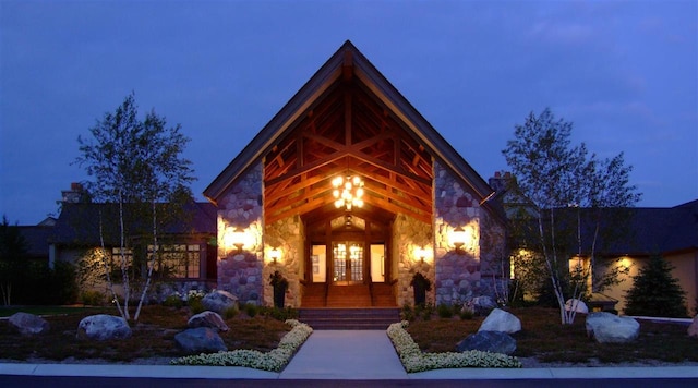 1871 Cherry Hill Ct, Harbor Springs, MI 49740 - exterior entry at night with a porch and stone siding