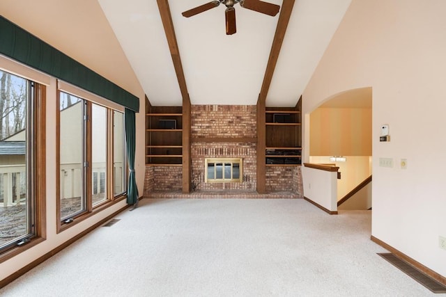 1871 Cherry Hill Ct, Harbor Springs, MI 49740 - unfurnished living room with lofted ceiling with beams, carpet flooring, visible vents, a ceiling fan, and a brick fireplace