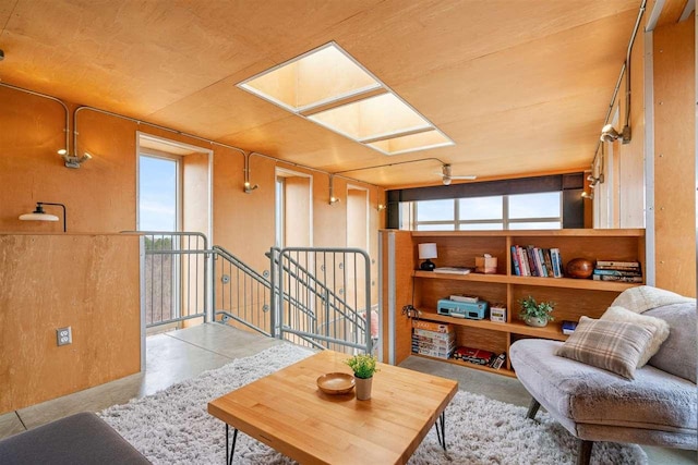 sitting room featuring a skylight, an upstairs landing, and a healthy amount of sunlight