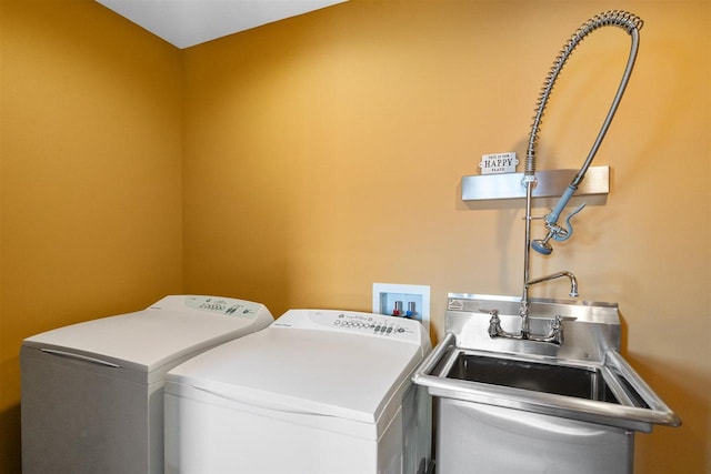 laundry area featuring washing machine and dryer, a sink, and laundry area