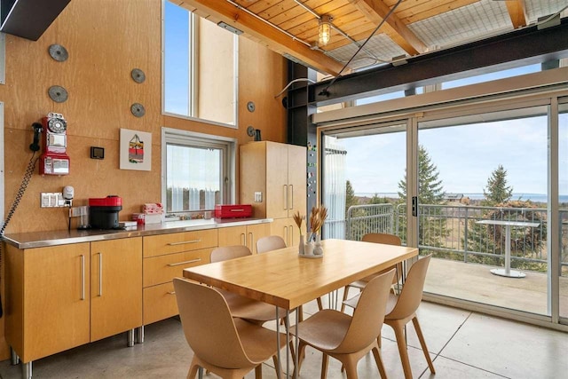 dining area featuring wooden ceiling, a towering ceiling, and beamed ceiling