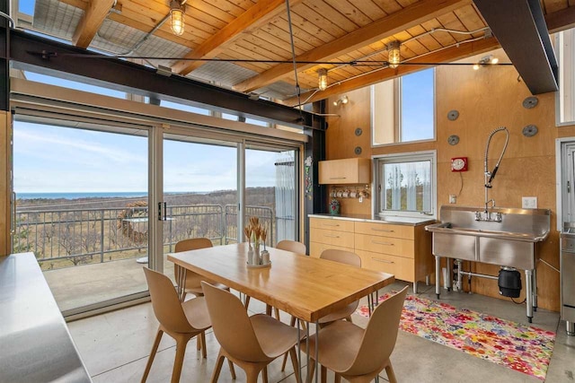 dining room with wooden ceiling, beam ceiling, and concrete floors