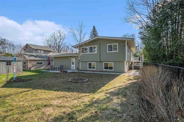 back of property with a lawn, an outdoor structure, fence, a patio, and a storage unit