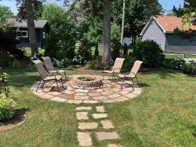 view of yard featuring a patio, an outdoor fire pit, and fence