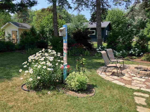 view of yard with an outdoor fire pit and fence