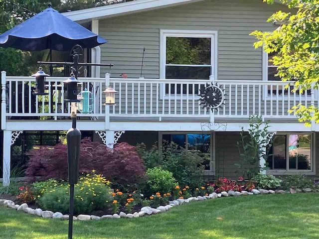 rear view of property with a deck and a yard