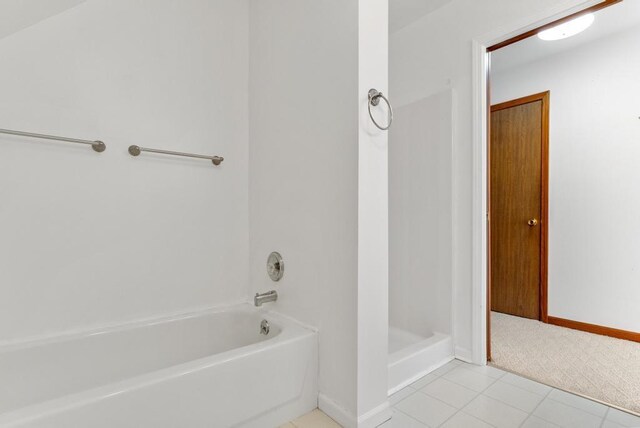 bathroom featuring a washtub, baseboards, tile patterned flooring, and a shower