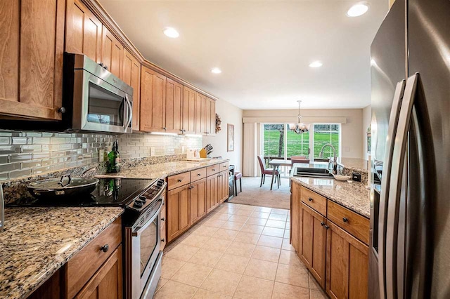 kitchen featuring recessed lighting, a sink, a chandelier, backsplash, and appliances with stainless steel finishes