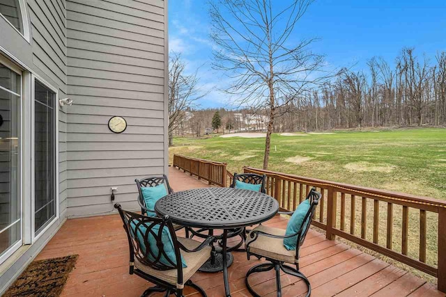 deck featuring a lawn and outdoor dining area