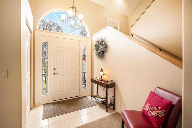 tiled foyer entrance featuring an inviting chandelier and a towering ceiling