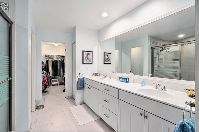 bathroom with a stall shower, tile patterned flooring, double vanity, and a sink