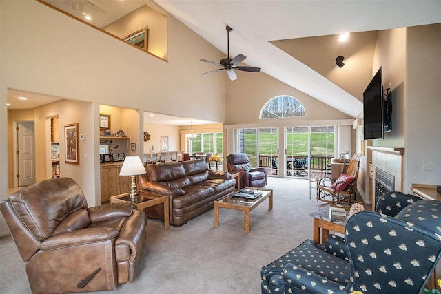 carpeted living area with high vaulted ceiling, a ceiling fan, a tile fireplace, and recessed lighting