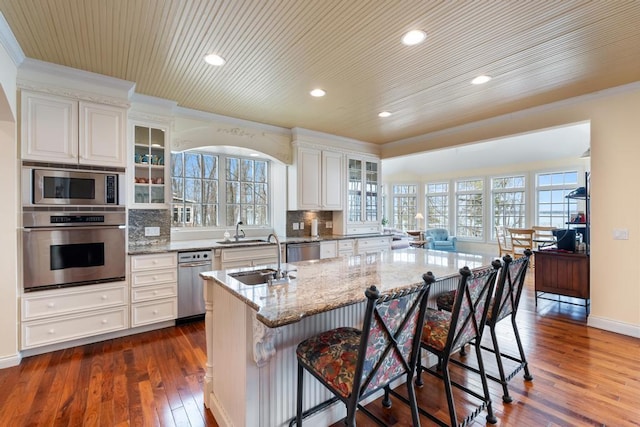 kitchen with crown molding, a sink, a healthy amount of sunlight, and stainless steel appliances