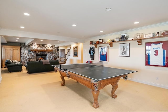 rec room with crown molding, carpet flooring, recessed lighting, and a stone fireplace