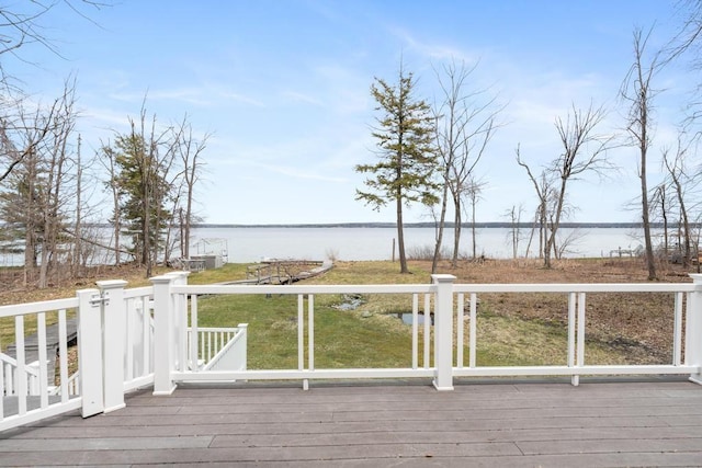 wooden deck with a lawn and a water view