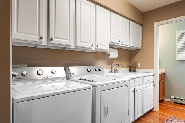 8913 Horseshoe Dr, Harbor Springs, MI 49740 - clothes washing area with cabinet space, a sink, washer and clothes dryer, light wood-style flooring, and baseboard heating