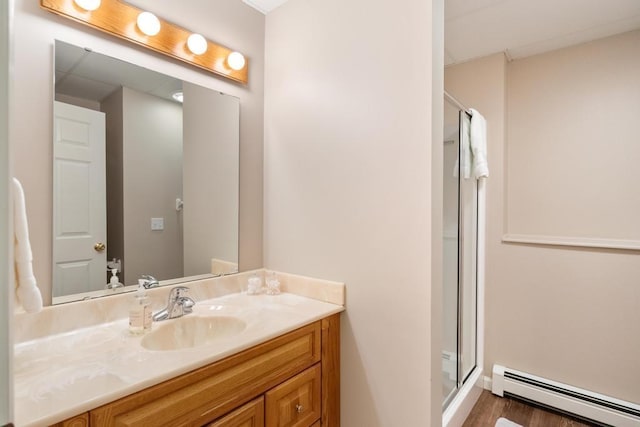 8913 Horseshoe Dr, Harbor Springs, MI 49740 - full bathroom with a shower stall, wood finished floors, a baseboard heating unit, and vanity