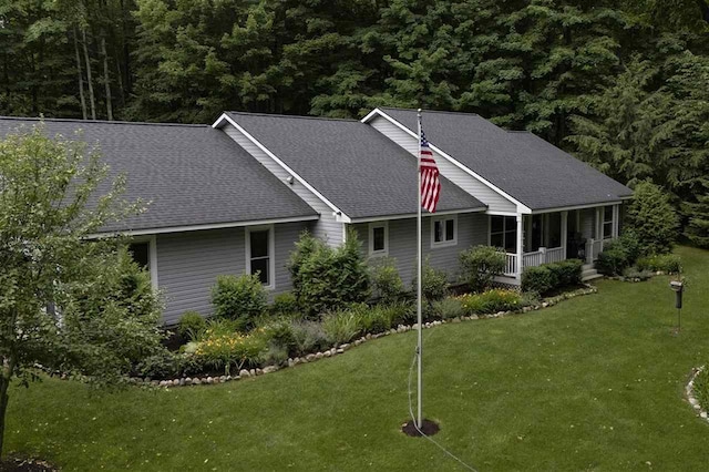 8913 Horseshoe Dr, Harbor Springs, MI 49740 - exterior space with covered porch, a front lawn, and a shingled roof
