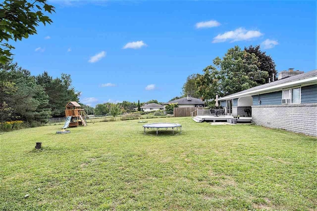 11601 Sequanota Heights Dr, Charlevoix, MI 49720 - view of yard featuring fence, a deck, a playground, and a trampoline