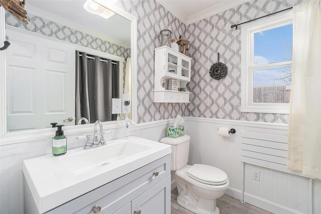 half bathroom with toilet, wallpapered walls, wood finished floors, and a wainscoted wall