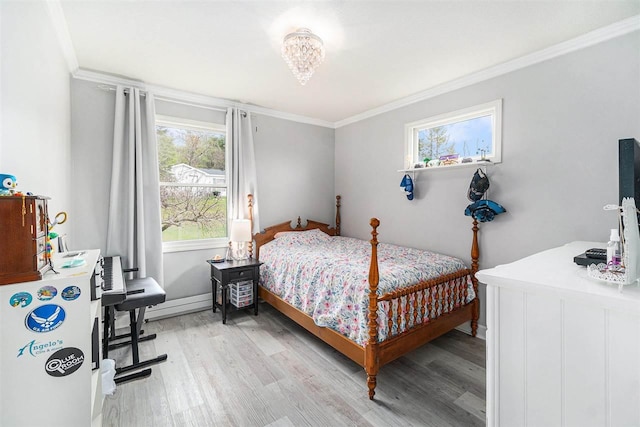 bedroom with light wood-style floors, ornamental molding, and baseboard heating