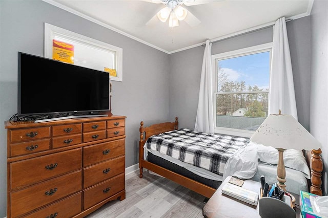 bedroom with baseboards, ornamental molding, a ceiling fan, and light wood-type flooring