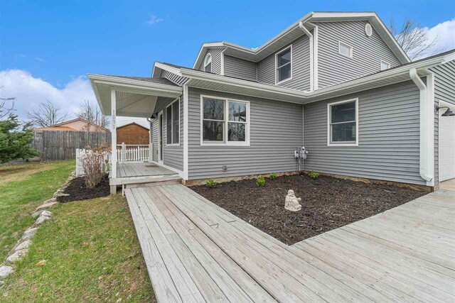 exterior space featuring fence, covered porch, and a garage