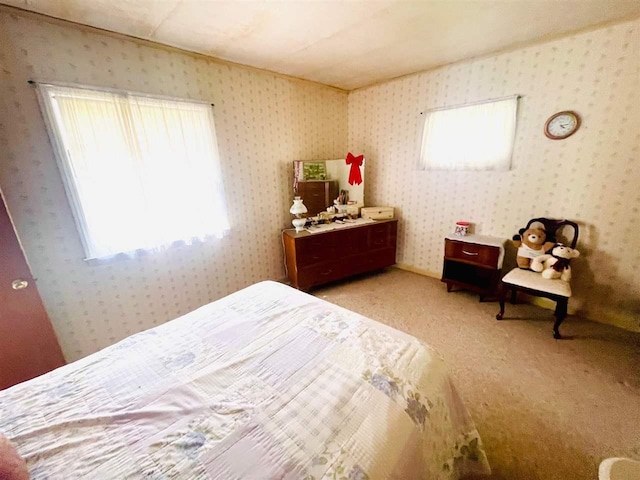 bedroom with light carpet and wallpapered walls