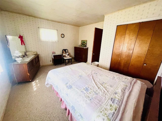 bedroom with a closet, light carpet, and wallpapered walls
