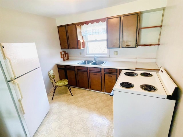 kitchen with a sink, light floors, white appliances, and light countertops