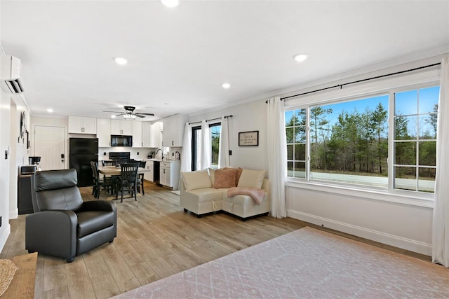 living room with ceiling fan, a wall mounted air conditioner, baseboards, light wood finished floors, and recessed lighting