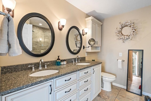 bathroom featuring a sink, baseboards, toilet, and double vanity