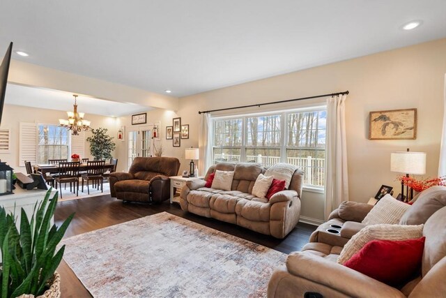 living area featuring recessed lighting, a notable chandelier, plenty of natural light, and dark wood finished floors