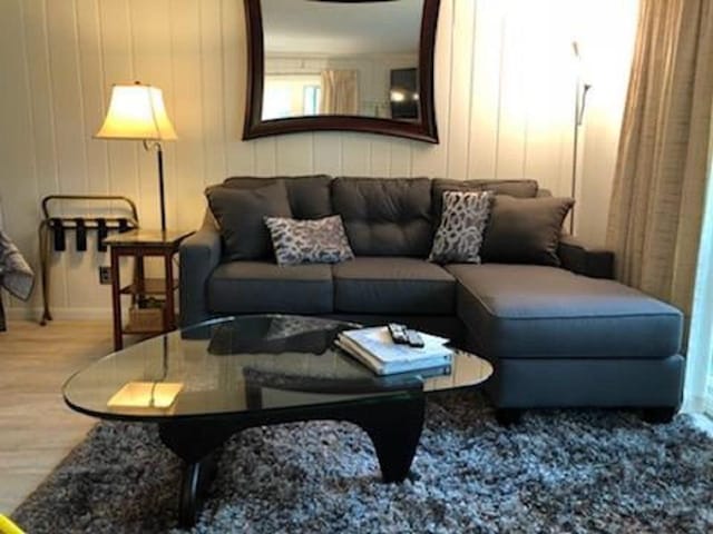 living area with baseboards and wood finished floors
