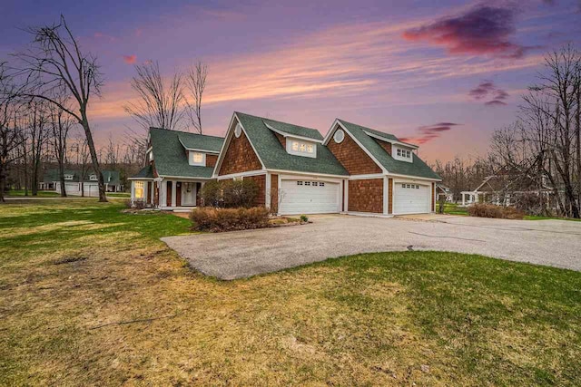view of front of house with a garage, driveway, a front yard, and covered porch