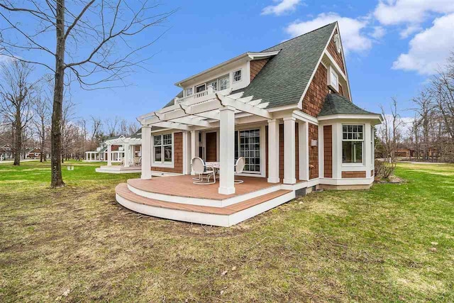 back of house with a yard, a pergola, a wooden deck, and a shingled roof