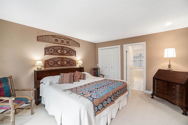 bedroom featuring baseboards, a closet, connected bathroom, and light colored carpet