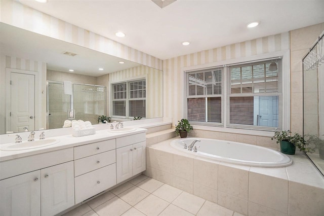 bathroom featuring a bath, a sink, tile patterned flooring, and a stall shower