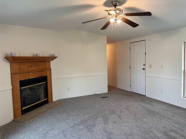 unfurnished living room with a ceiling fan, a textured ceiling, a glass covered fireplace, and carpet