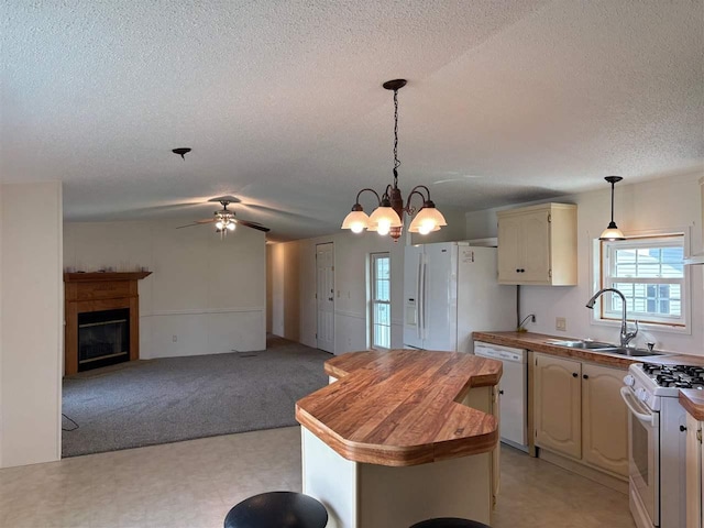 kitchen with white appliances, a textured ceiling, a sink, wood counters, and ceiling fan with notable chandelier